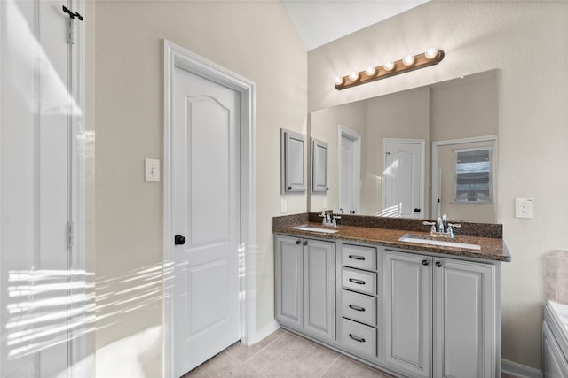 bathroom featuring tile patterned flooring, vanity, and vaulted ceiling