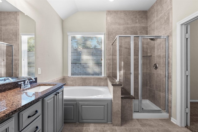 bathroom with tile patterned flooring, vanity, plus walk in shower, and lofted ceiling