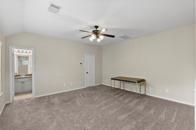 carpeted empty room with ceiling fan, lofted ceiling, and sink