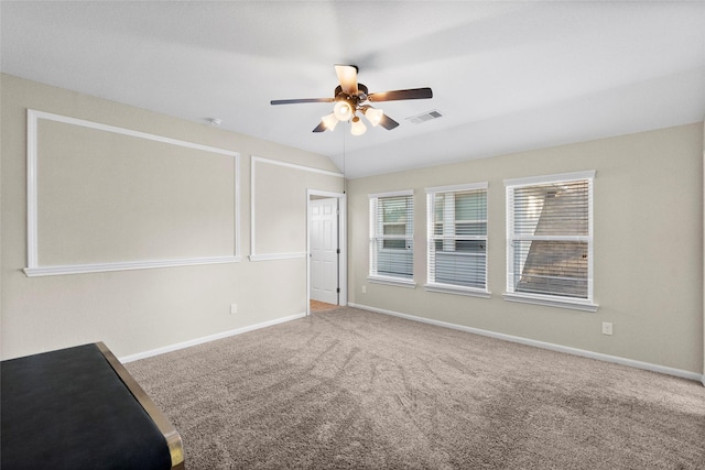 carpeted spare room featuring ceiling fan and lofted ceiling