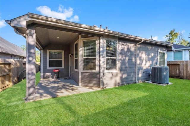 rear view of property featuring central AC, a patio area, and a lawn