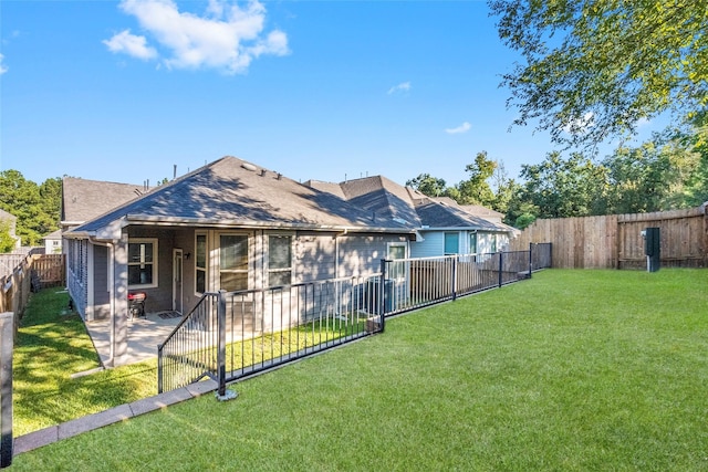 rear view of property with a lawn and a patio area