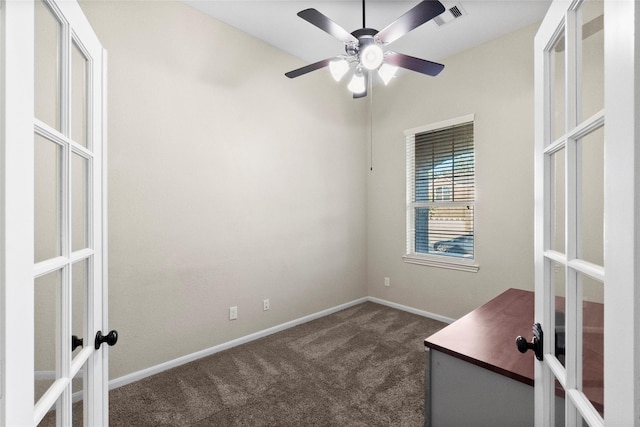 unfurnished office featuring dark colored carpet, french doors, and ceiling fan