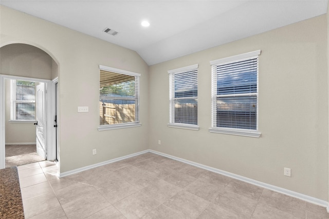 unfurnished room featuring light tile patterned floors and vaulted ceiling