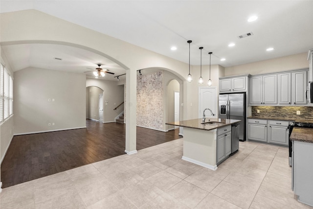 kitchen featuring gray cabinetry, ceiling fan, sink, a center island with sink, and light hardwood / wood-style flooring