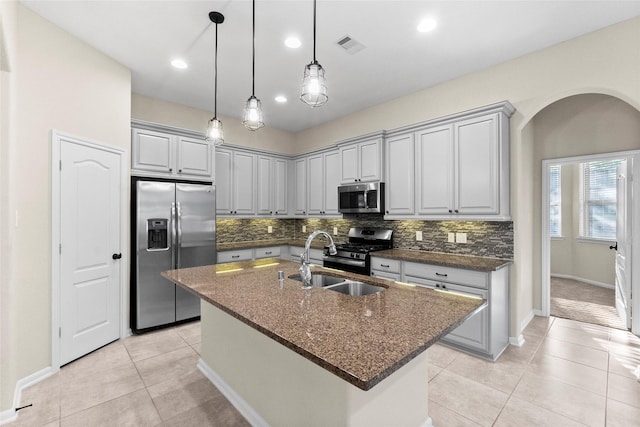 kitchen with gray cabinets, sink, an island with sink, and appliances with stainless steel finishes