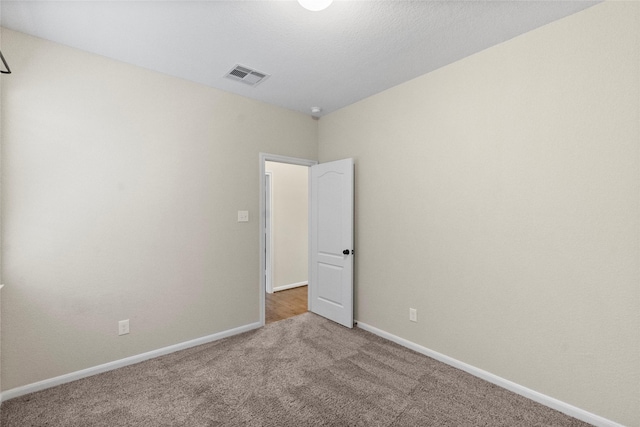 unfurnished room featuring light carpet