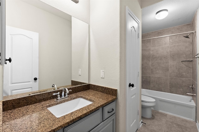 full bathroom with tiled shower / bath, tile patterned flooring, vanity, and toilet