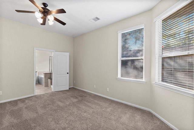 unfurnished bedroom with light colored carpet, ceiling fan, and ensuite bathroom