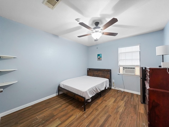 bedroom featuring ceiling fan, cooling unit, and dark hardwood / wood-style flooring