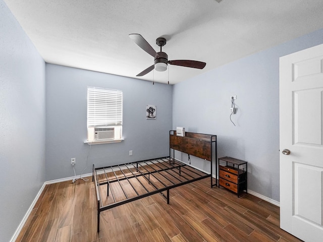 bedroom with ceiling fan, dark hardwood / wood-style flooring, and cooling unit