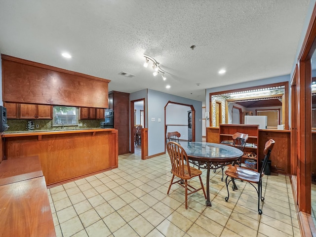 tiled dining room featuring a textured ceiling