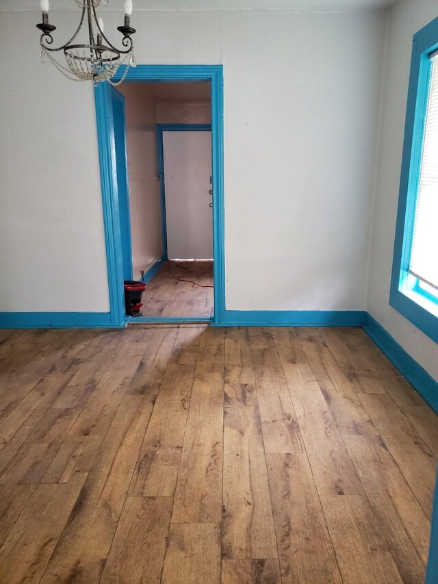 unfurnished dining area with hardwood / wood-style floors and a chandelier