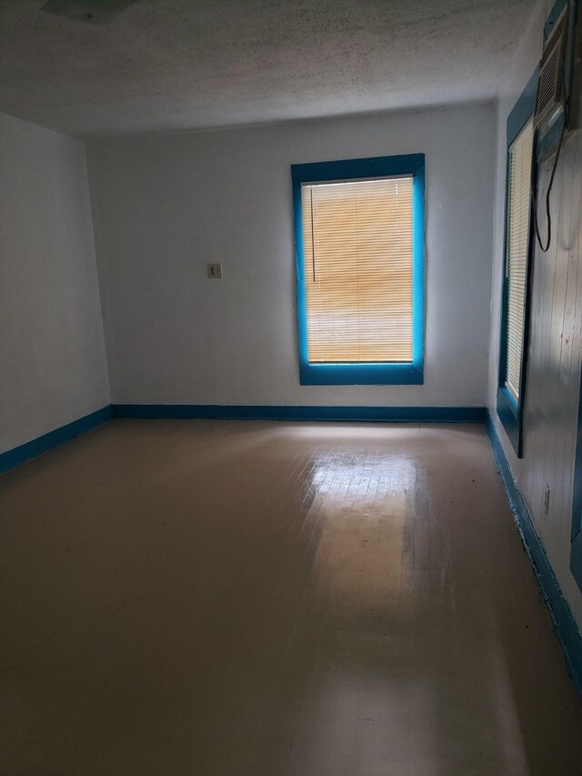 unfurnished room featuring hardwood / wood-style floors and a textured ceiling