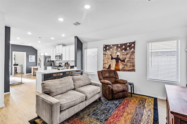 living room with lofted ceiling and light wood-type flooring