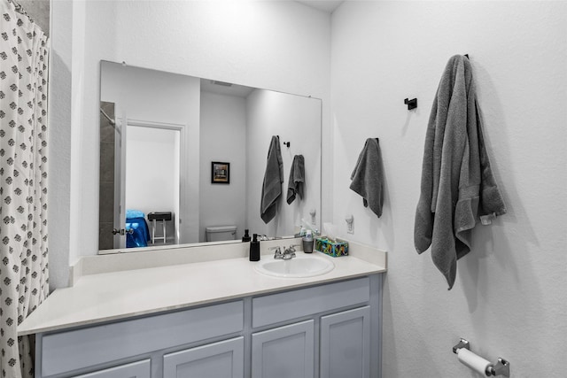 bathroom featuring a shower with curtain, vanity, and toilet