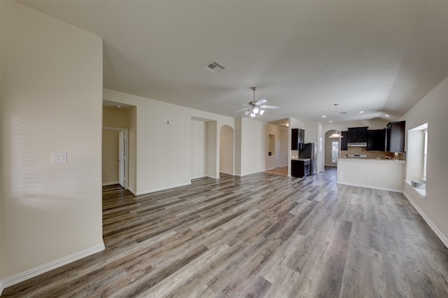 unfurnished living room with ceiling fan, hardwood / wood-style floors, and vaulted ceiling