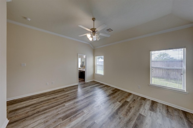 spare room with crown molding, vaulted ceiling, and light wood-type flooring