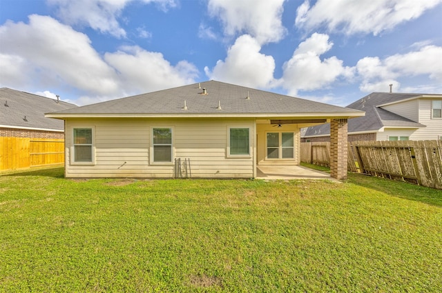 rear view of property with ceiling fan, a yard, and a patio