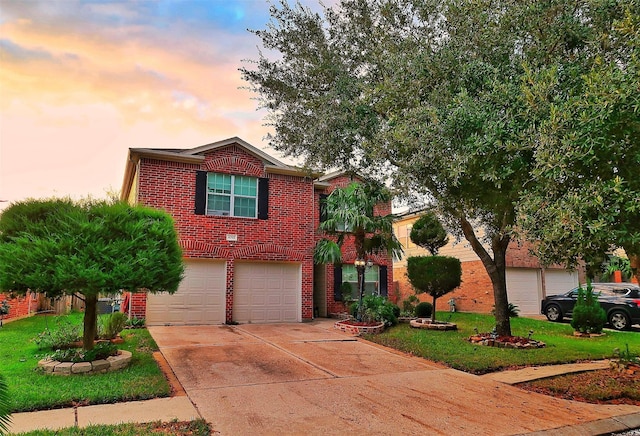 traditional home featuring a garage, concrete driveway, brick siding, and a front lawn