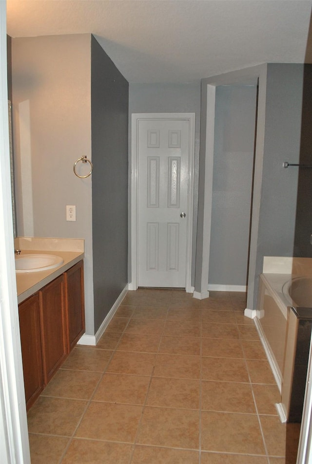 bathroom with tile patterned floors, vanity, and a bath