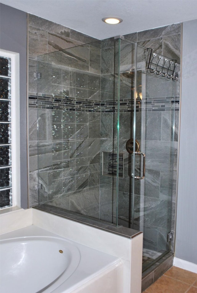 full bathroom featuring a garden tub, a shower stall, and tile patterned floors