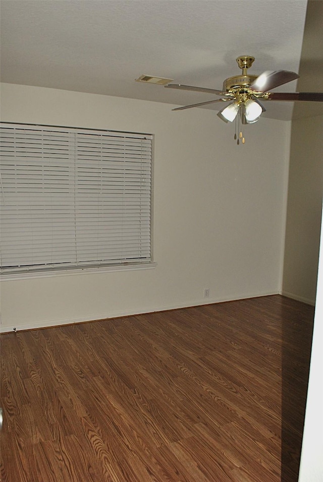 spare room featuring ceiling fan and dark wood-type flooring