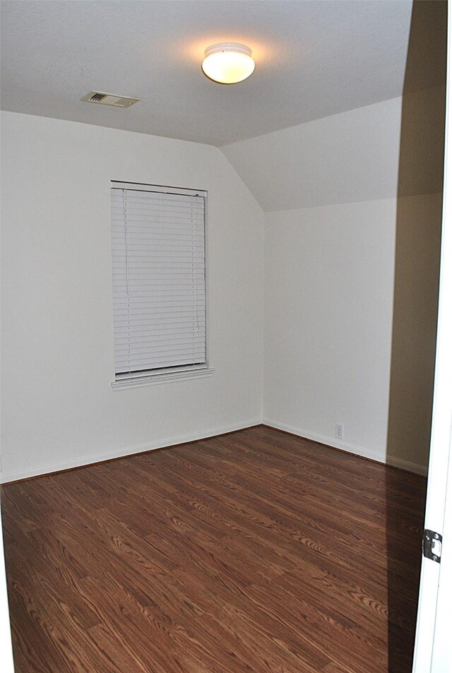 additional living space with dark hardwood / wood-style flooring and lofted ceiling