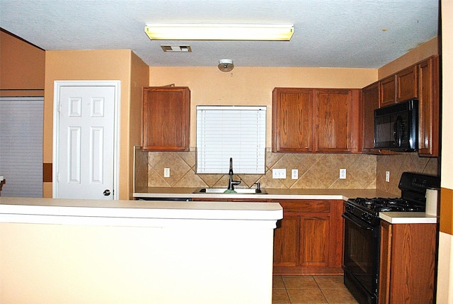 kitchen with tasteful backsplash, sink, light tile patterned floors, and black appliances