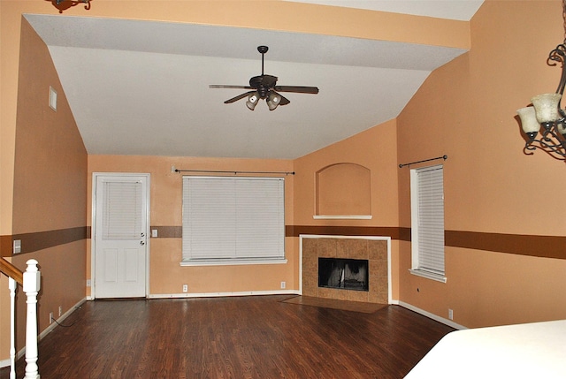 unfurnished bedroom with wood-type flooring, vaulted ceiling, ceiling fan, and a tiled fireplace