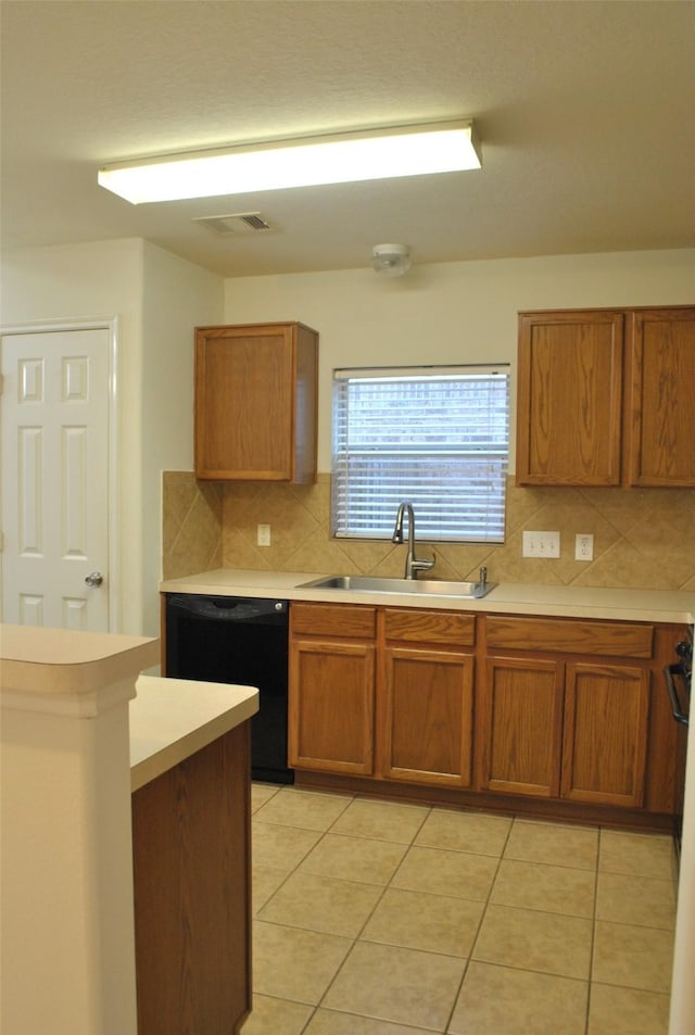 kitchen with visible vents, dishwasher, brown cabinets, light countertops, and a sink