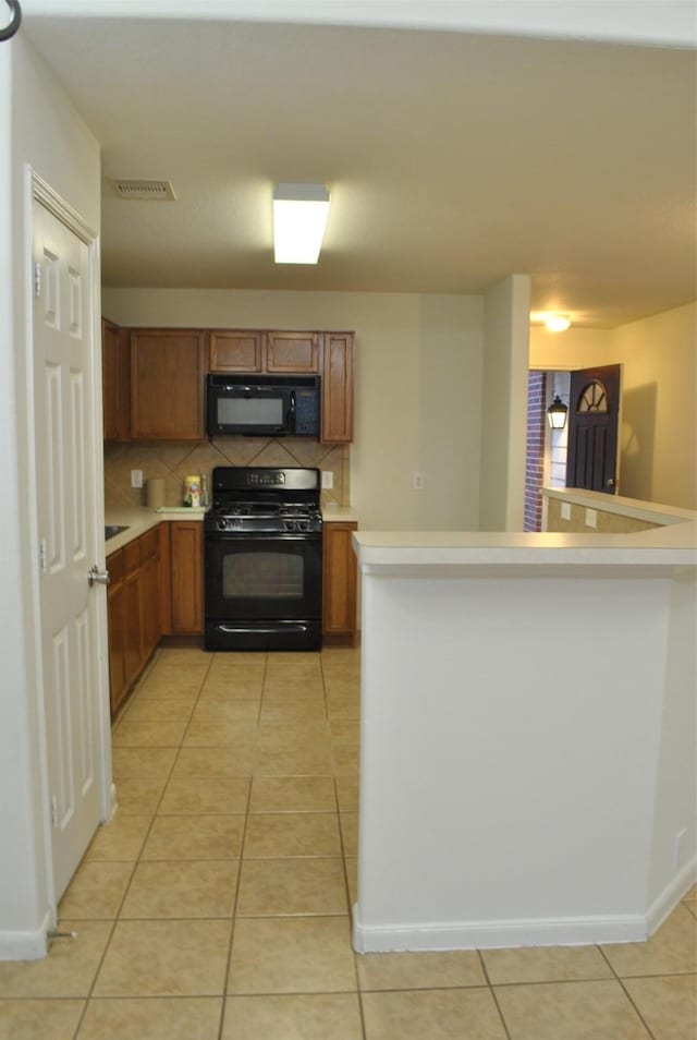 kitchen with black appliances, light countertops, and brown cabinets