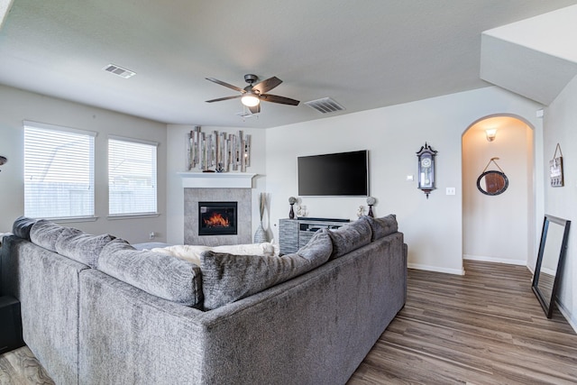 living room featuring a fireplace, wood-type flooring, and ceiling fan