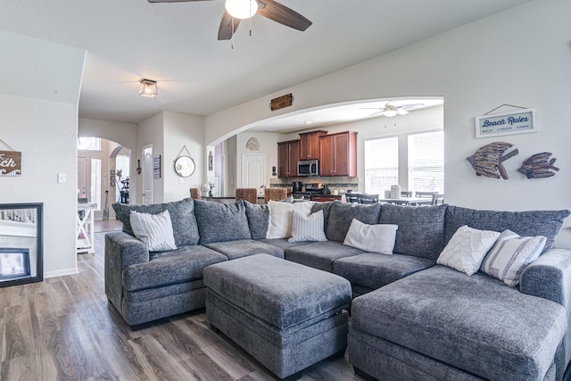 living room with ceiling fan and dark wood-type flooring