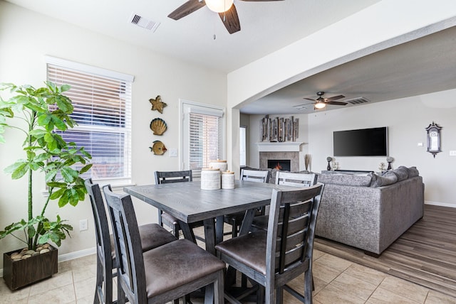 dining area with light wood-type flooring and ceiling fan