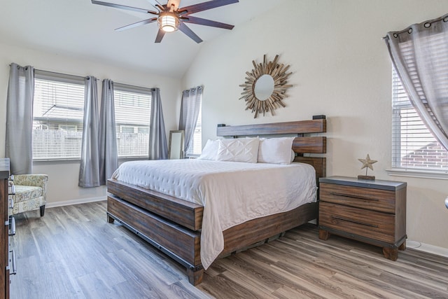 bedroom featuring hardwood / wood-style flooring, ceiling fan, and multiple windows