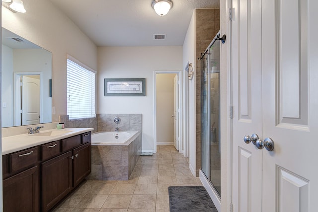 bathroom with tile patterned flooring, vanity, and shower with separate bathtub