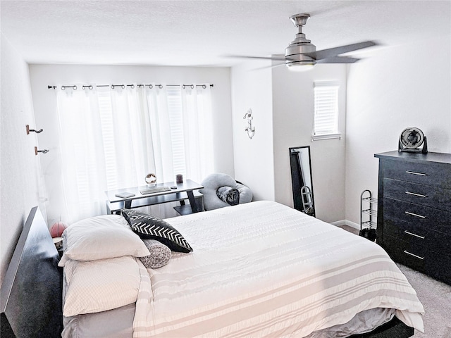 carpeted bedroom with ceiling fan and a textured ceiling