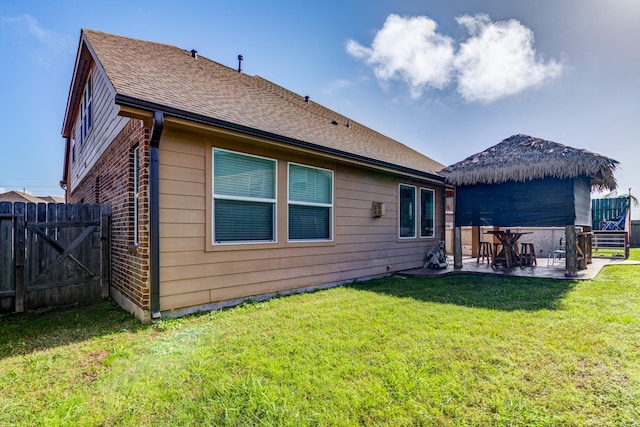 rear view of property featuring a lawn and a patio area