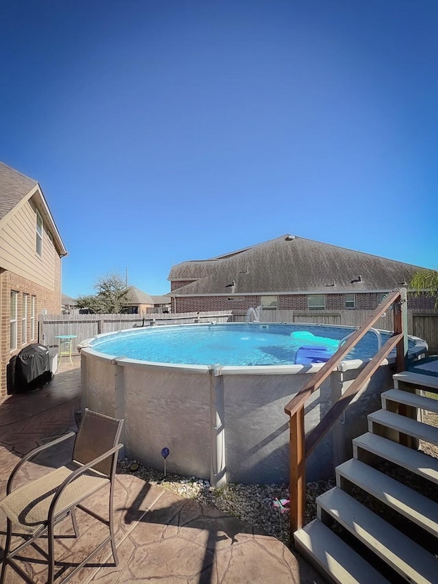 view of pool featuring area for grilling and a patio