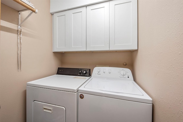 laundry area with washer and dryer and cabinets