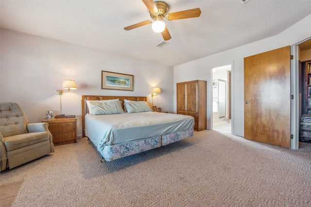 carpeted bedroom featuring ceiling fan, a textured ceiling, and ensuite bath