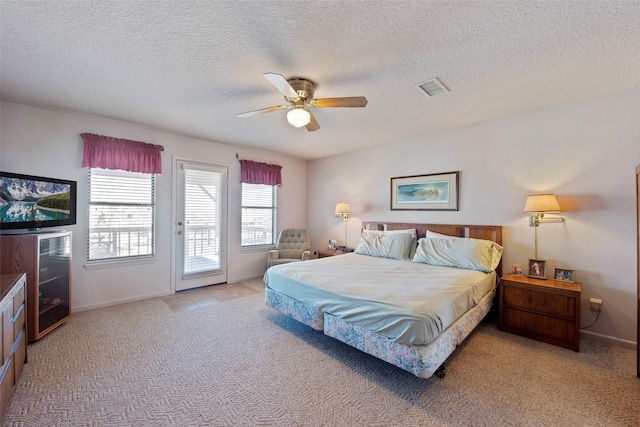 bedroom with access to exterior, a textured ceiling, light colored carpet, and ceiling fan