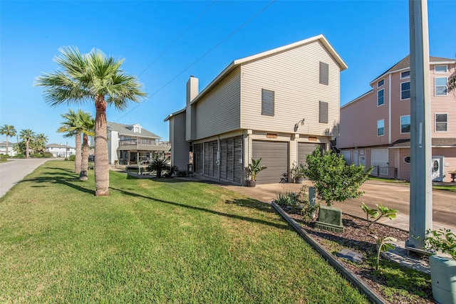 back of property featuring a garage and a yard