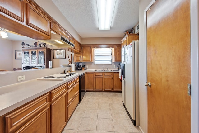 kitchen with kitchen peninsula, a textured ceiling, white appliances, sink, and light tile patterned flooring