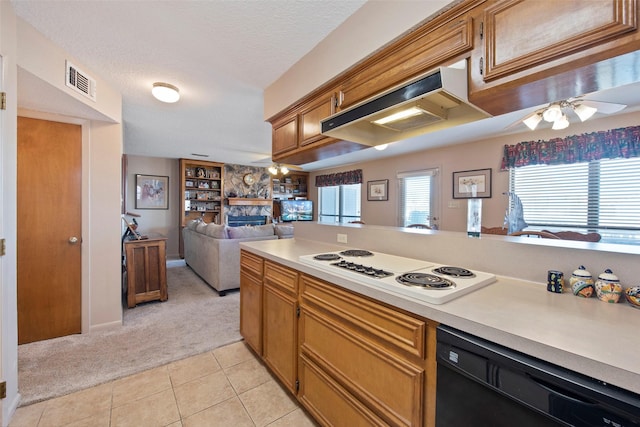 kitchen featuring dishwasher, white gas stovetop, a stone fireplace, ceiling fan, and light tile patterned floors