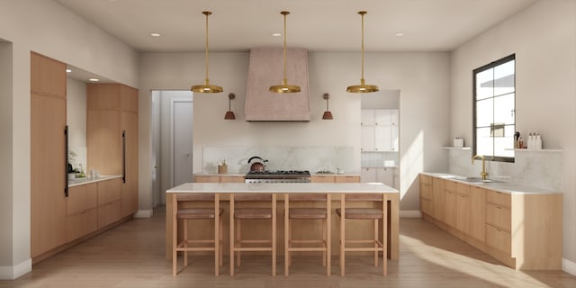 kitchen featuring pendant lighting, light hardwood / wood-style floors, light brown cabinetry, and sink