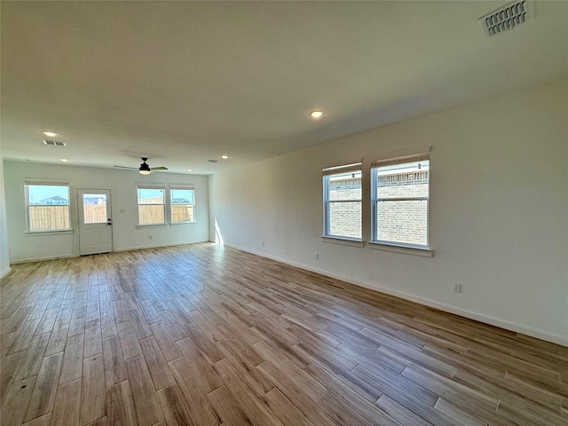 spare room with a ceiling fan, baseboards, visible vents, and wood finished floors