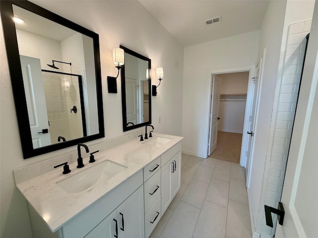 bathroom featuring visible vents, a sink, a shower stall, and a spacious closet