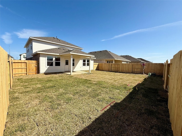 back of property with a yard, a patio, and a fenced backyard